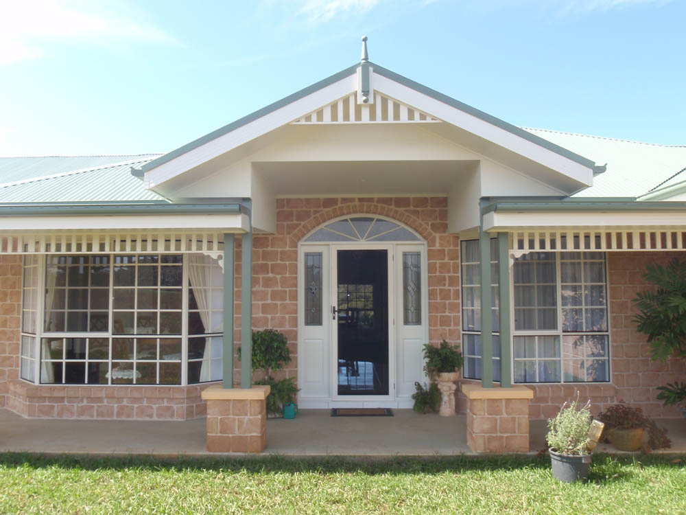Sandstone-coloured family home with a gabled veranda, built by Loader Build + Design in Valla
